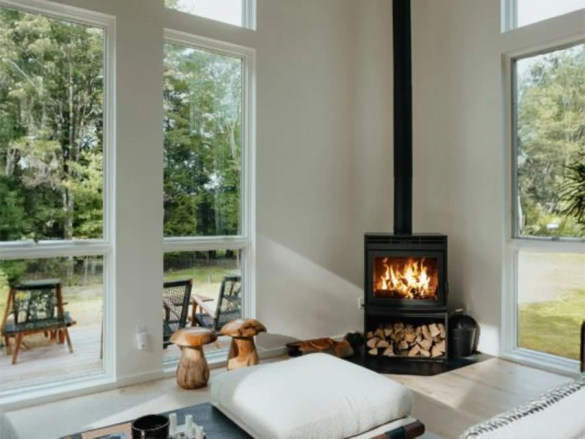 Int&eacute;rieur r&eacute;sidentiel moderne avec po&ecirc;le &agrave; bois cylindrique noir en fonctionnement