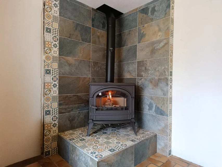 Cheminée moderne encastrée en fonctionnement avec flammes vives et bûches en combustion